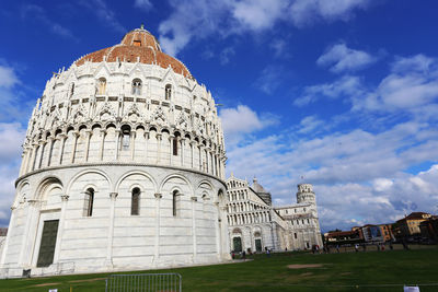 Low angle view of pisa cathedral and dome against cloudy sky