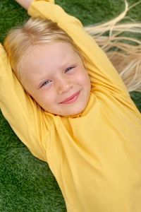 Portrait of young woman lying on grass