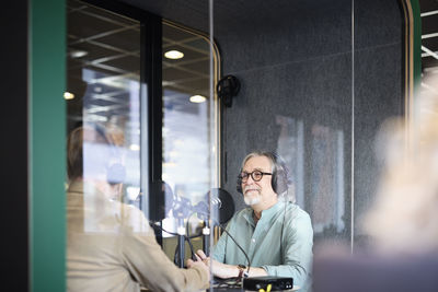 Male radio presenter talking with his guest on radio show or podcast