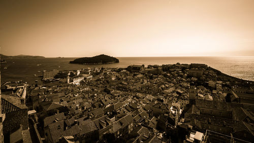 High angle view of town by sea against clear sky