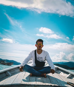 Portrait of young man standing against sky