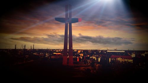 Illuminated communications tower against sky at sunset