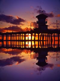 Pier over lake against sky during sunset