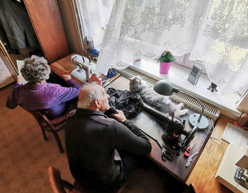 High angle view of senior couple sitting by window at home