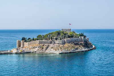 View of fort on island against clear sky during sunny day