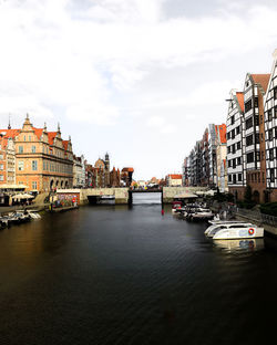 River amidst buildings in city against sky