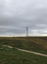 Electricity pylon on field against sky