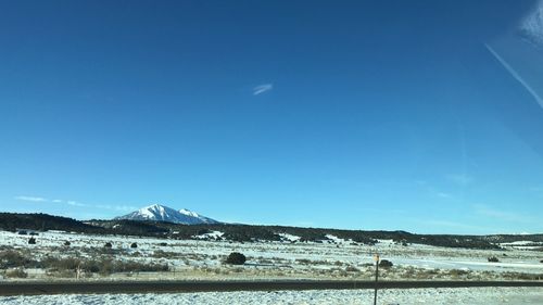 Scenic view of snowcapped mountains against blue sky