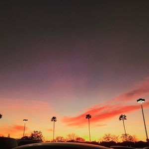 Low angle view of silhouette street lights against sky during sunset