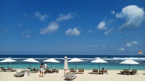 Group of people on beach against sky