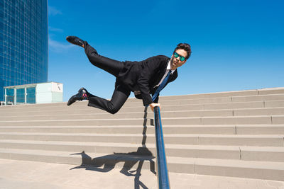 Low angle view of man jumping against clear sky