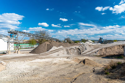 Heaps of gravel and crushed on blue sky at an industrial cement plant.