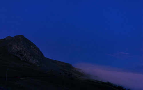 Scenic view of mountains against clear blue sky at night