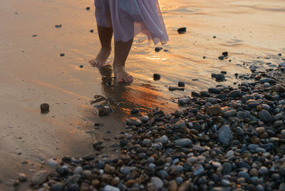 Low section of man standing on beach