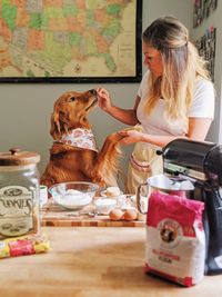 Woman playing with dog at home