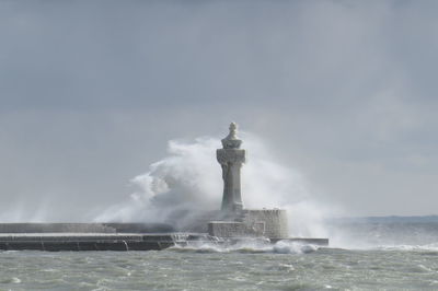 Lighthouse against cloudy sky