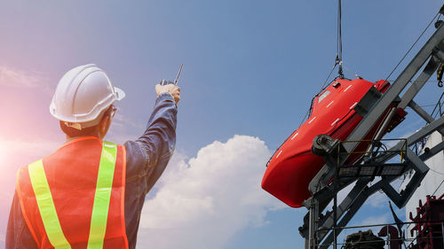 Man working on construction site against sky