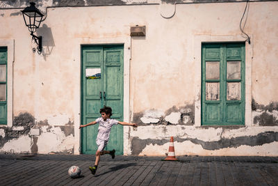 Full length of boy playing on wall