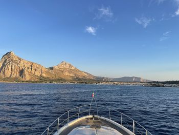 Scenic view of sea and mountains against blue sky