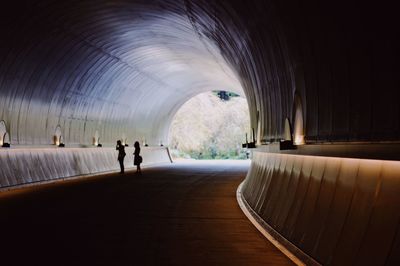 Silhouette people standing in tunnel