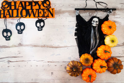 Directly above view of pumpkins and witch against wooden table