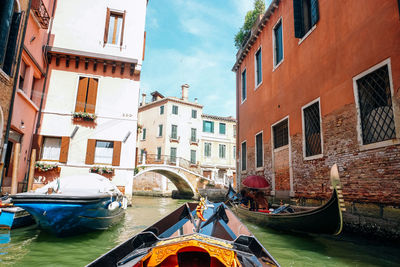 Canal amidst buildings in city against sky