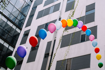 Low angle view of colorful balloons against building