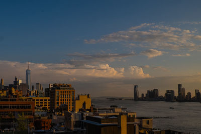 Buildings in city against sky during sunset