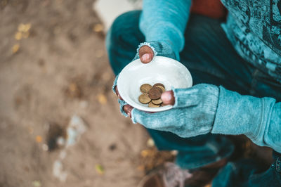 High angle view of beggar with coins in bowl
