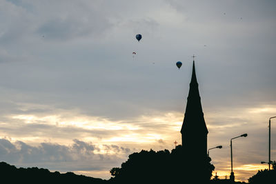 Low angle view of silhouette building against cloudy sky