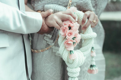 Midsection of woman holding flower bouquet