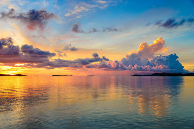 Scenic view of sea against dramatic sky during sunset