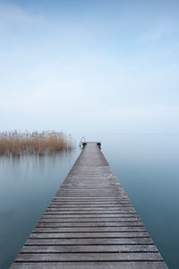 Pier over lake against sky