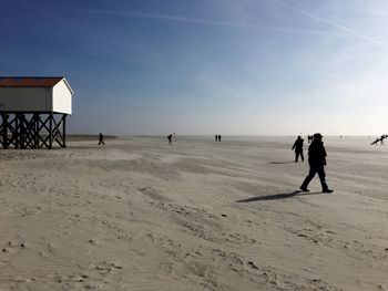 Man walking on snow covered beach