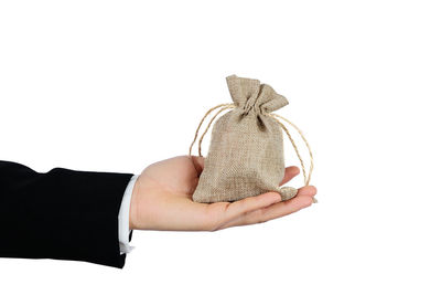 Close-up of hand holding umbrella against white background