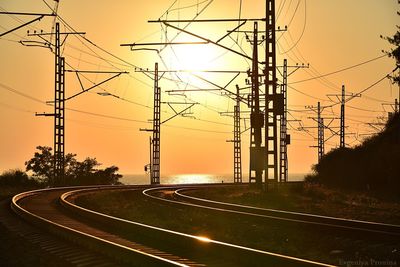 Railroad tracks against sky during sunset