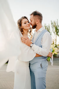 Couple embracing while standing outdoors