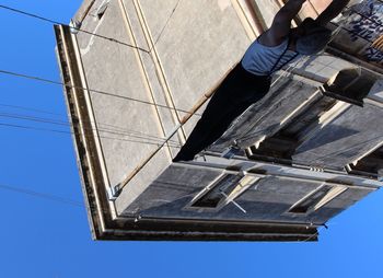 Low section of man working against clear sky