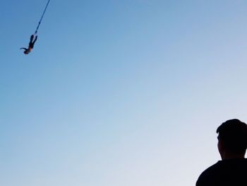 Low angle view of silhouette person against clear sky