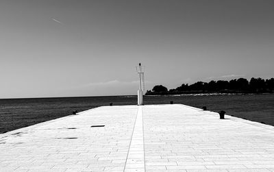 Footpath by street against clear sky