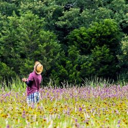 Man standing in field against trees