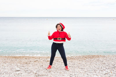 Full length portrait of young woman standing on beach