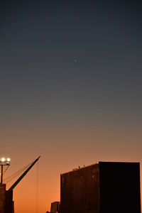 Low angle view of silhouette buildings against sky at sunset