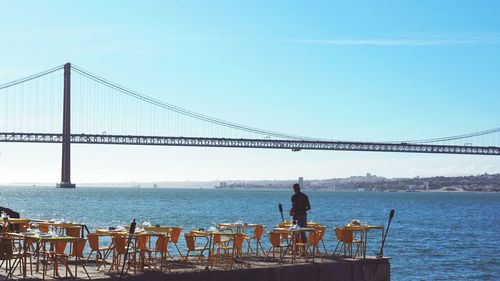 Suspension bridge over sea against sky