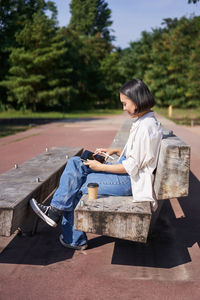 Side view of man sitting on field