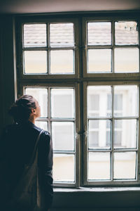 Woman looking through window