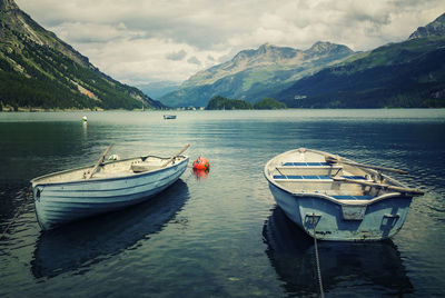 Boats moored in lake against sky