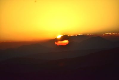 Scenic view of silhouette mountains against romantic sky at sunset