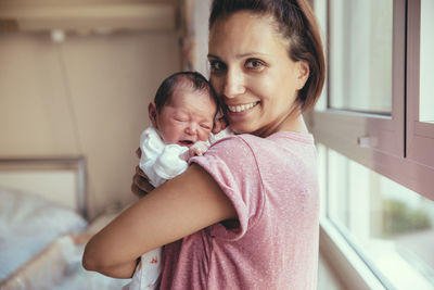 Portrait of happy mother holding her newborn baby in hospital