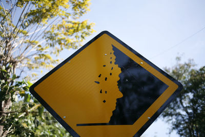Low angle view of road sign against sky